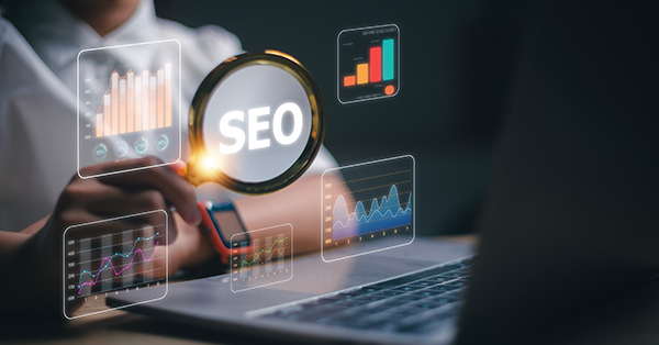 Women use magnifying glasses and computers for SEO research