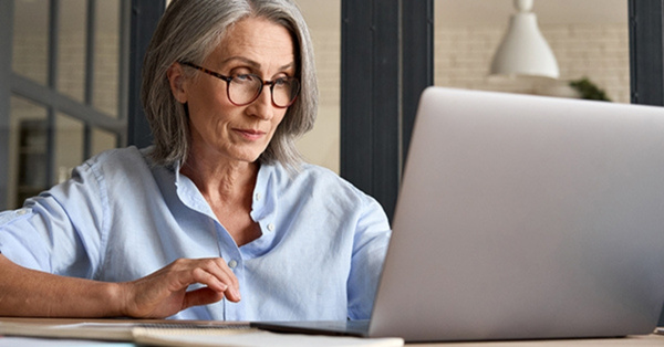 Older woman working on laptop at home office