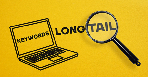 Long-tail keywords illustration with laptop and magnifying glass.
