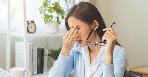 stressed woman removing glasses