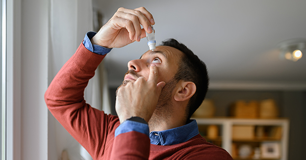 Man putting on eye drops