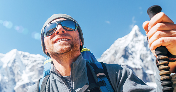 Man with glasses climbing a mountain