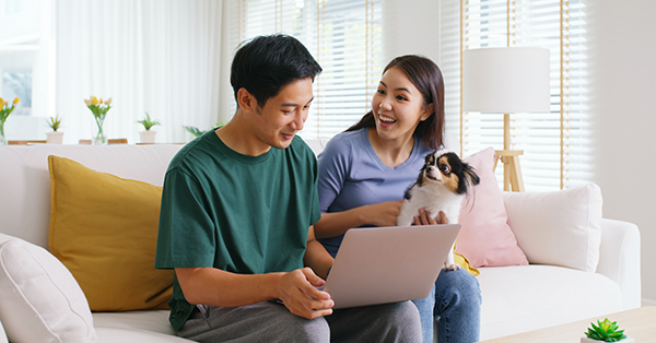 young family with pet dog using laptop