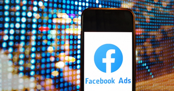 Smartphone showing Facebook Ads logo on digital background.