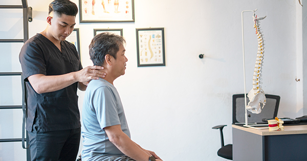 A chiropractor assists a patient in a healing session focusing on spinal health and posture.
